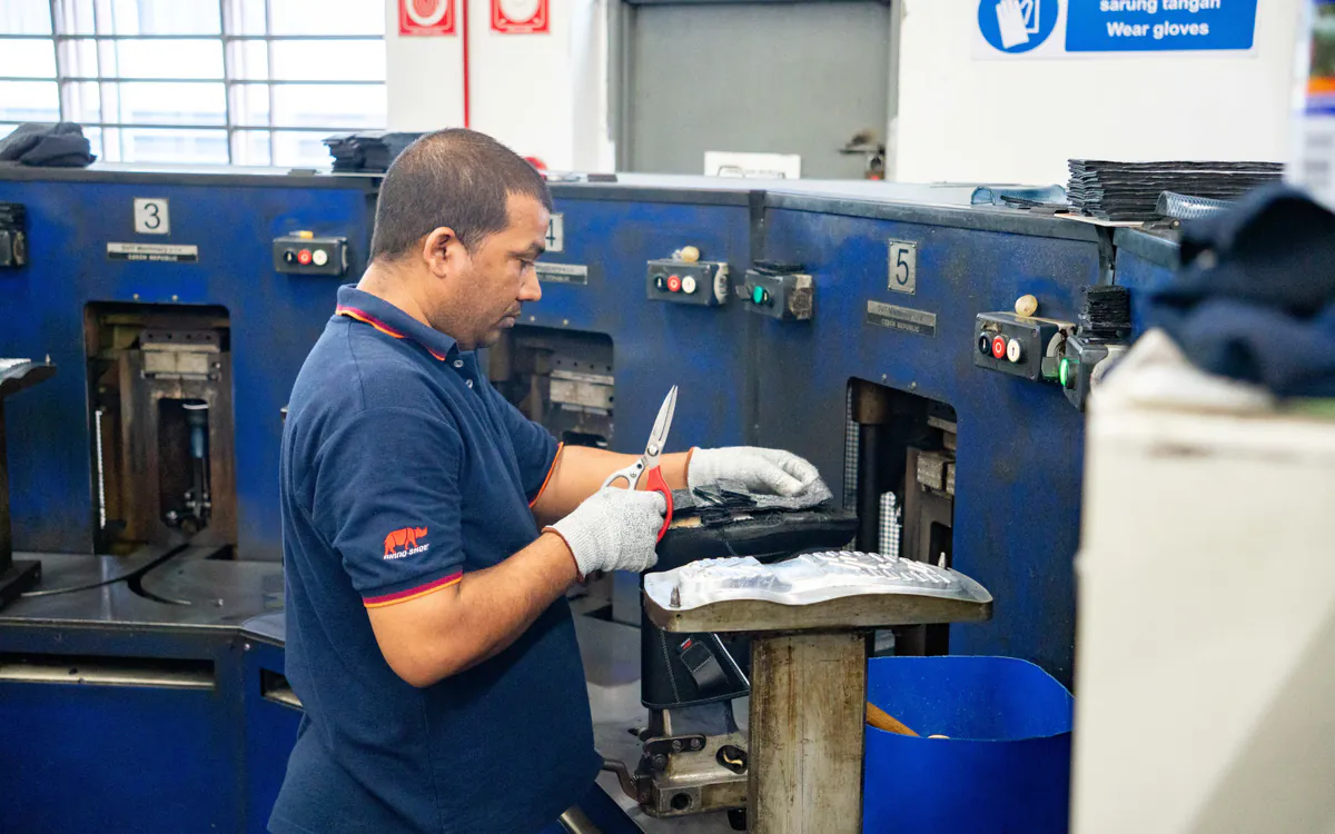 RHINO SHOE operator trimming safety shoe components with care