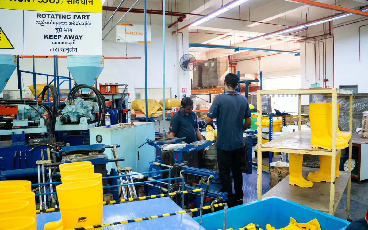 Yellow RHINO SHOE PVC safety boots being manufactured on injection equipment